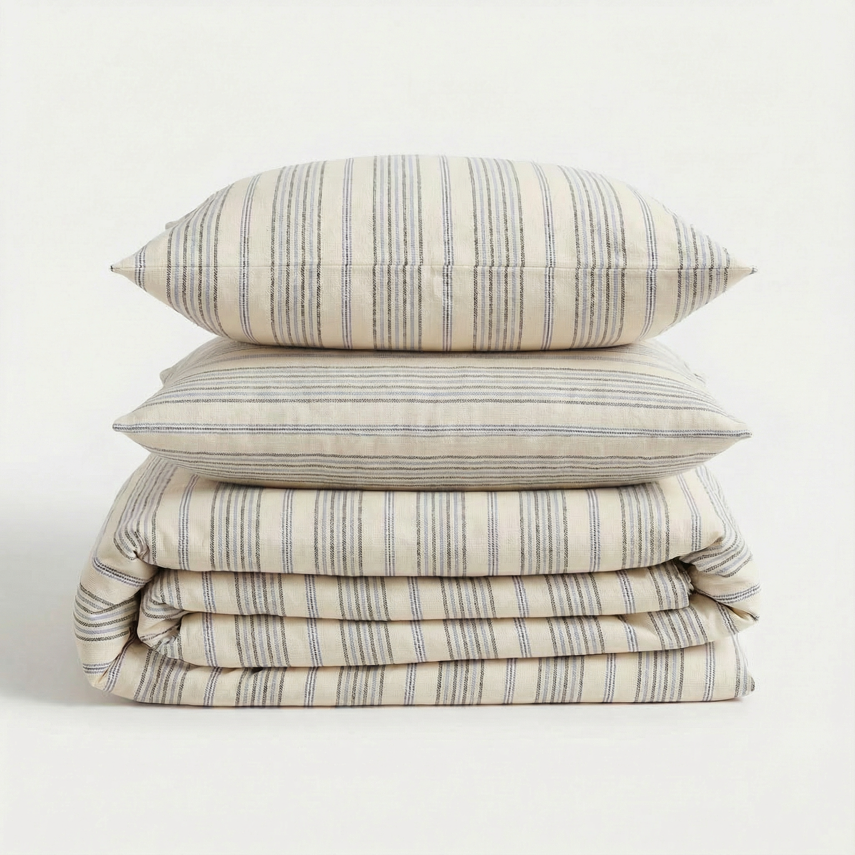 Stack of blue striped bedding set with a pillow on a white background