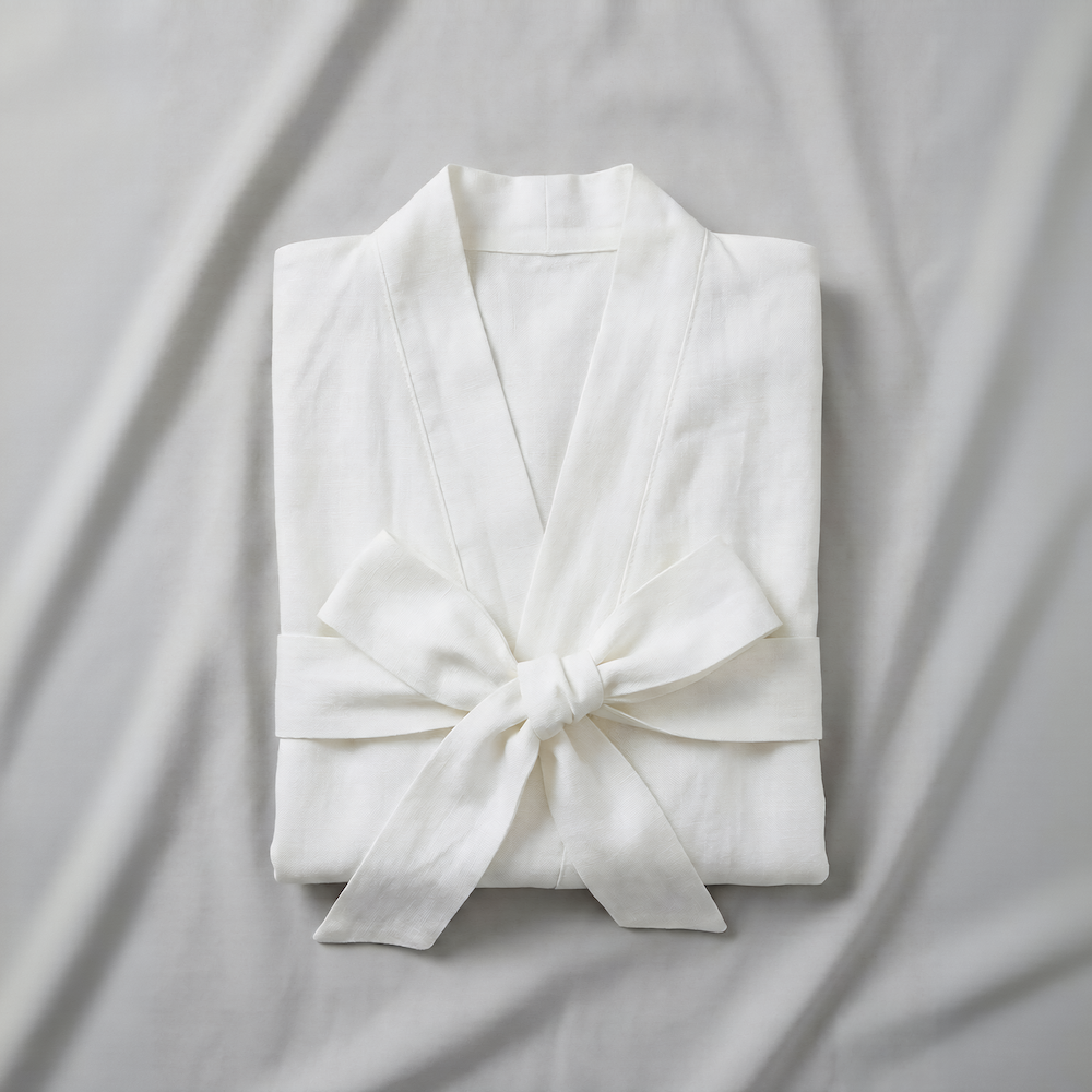 White folded atelier orea kimono robe with a knot on a light gray background
