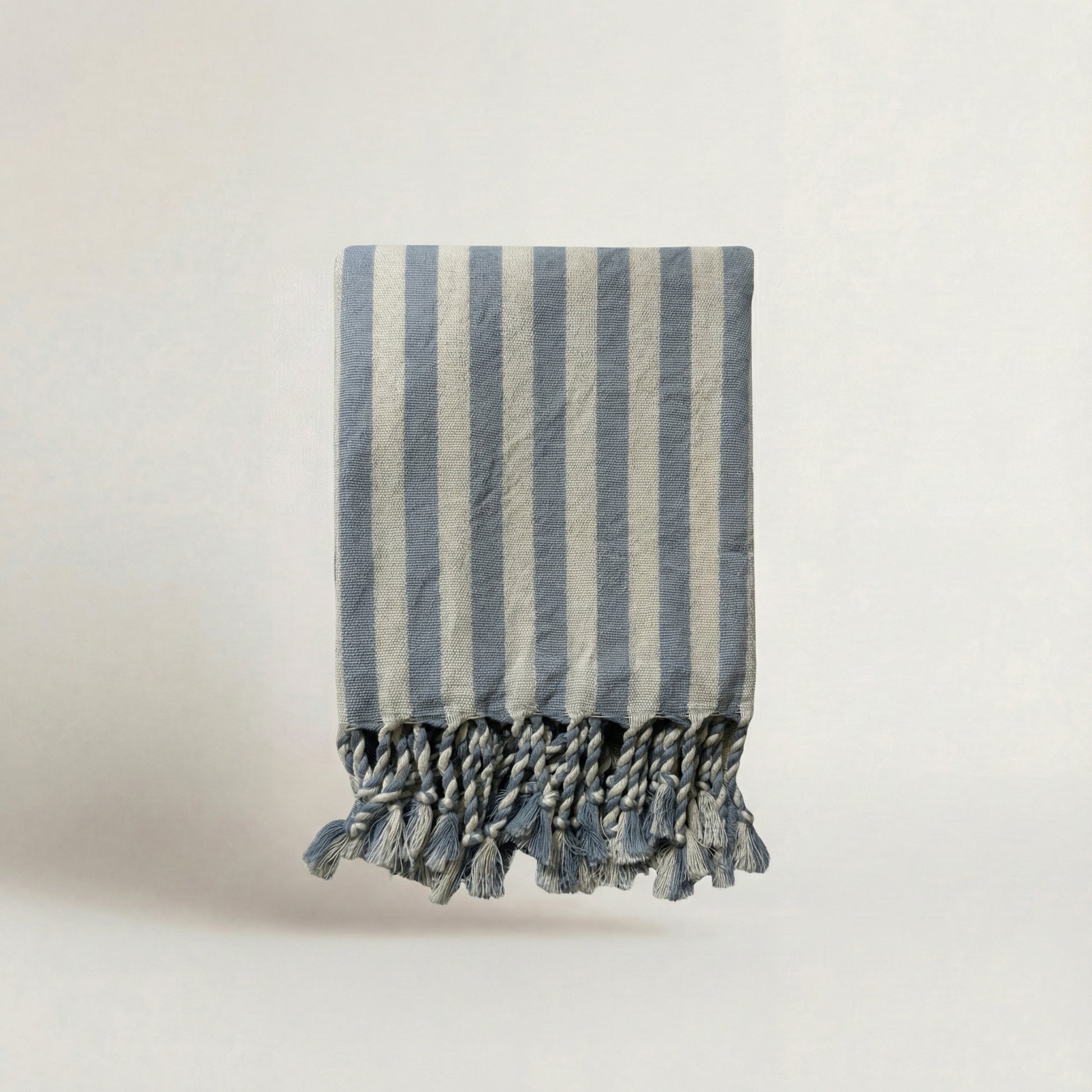 Baby blue striped turkish cotton towel with tassels on a light background from atelier orea