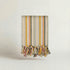 Handwoven towel with pastel pink, yellow, green, blue stripes and tassels on a light background
