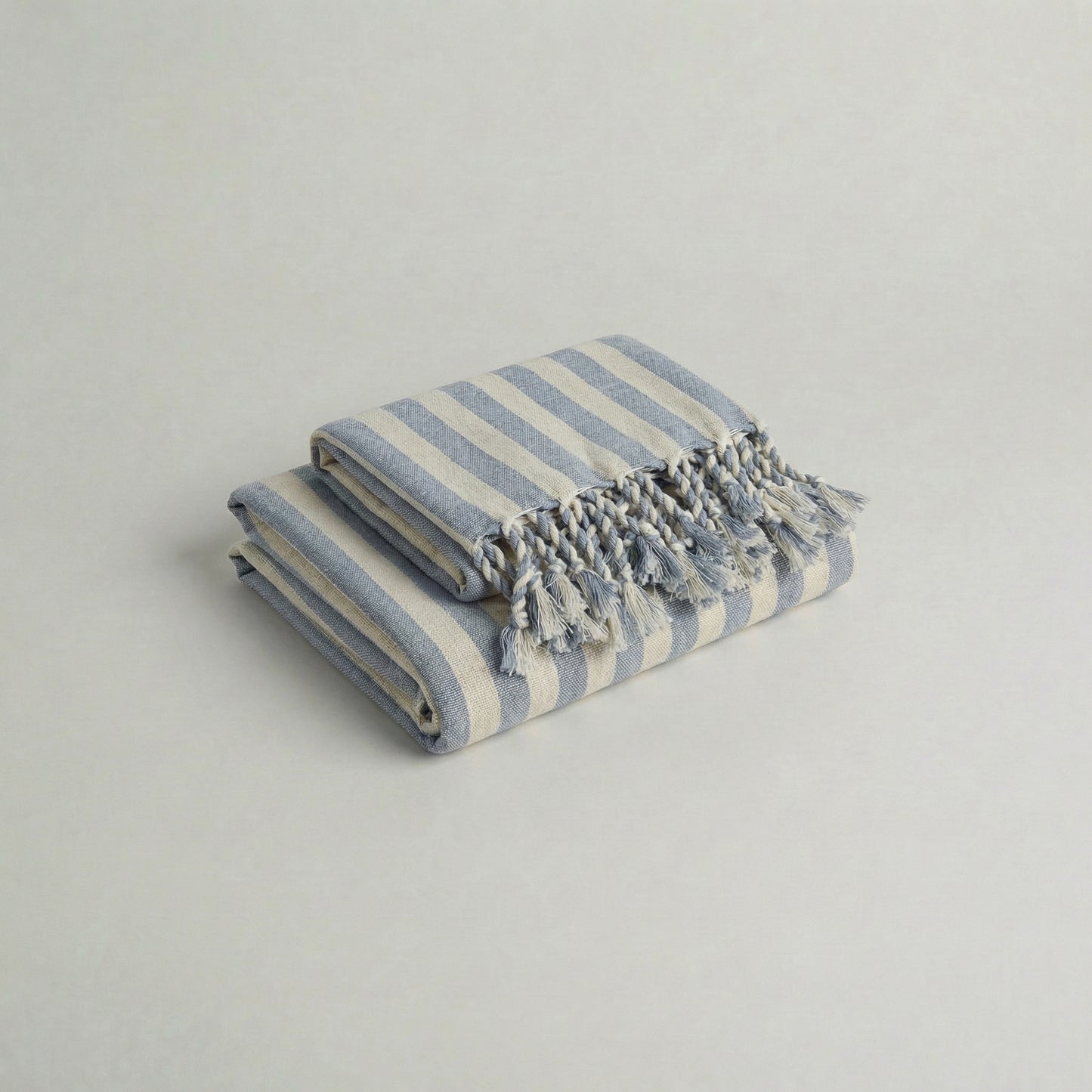 Folded handwoven cotton towel set with baby blue stripes and tassels