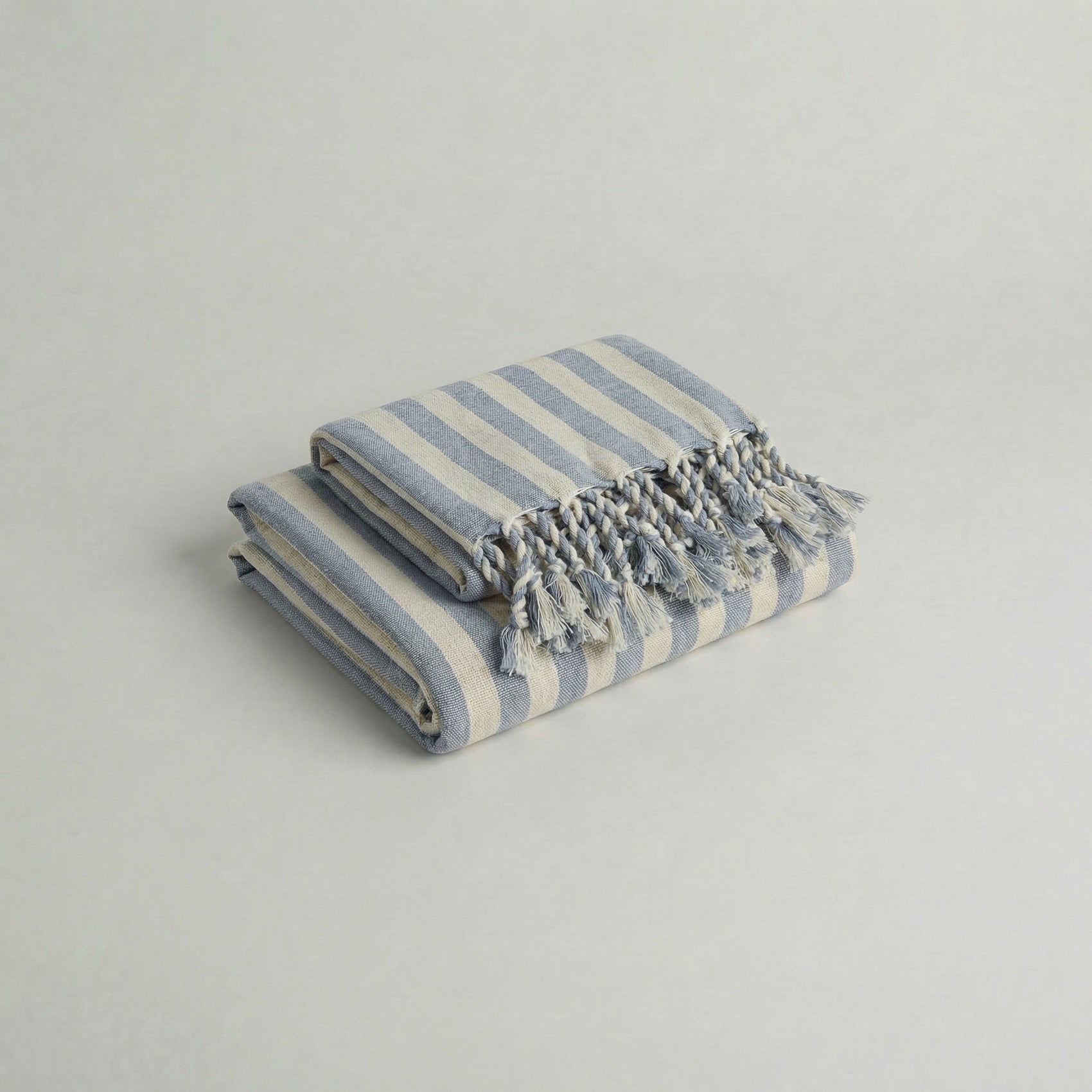 Folded handwoven cotton towel set with baby blue stripes and tassels