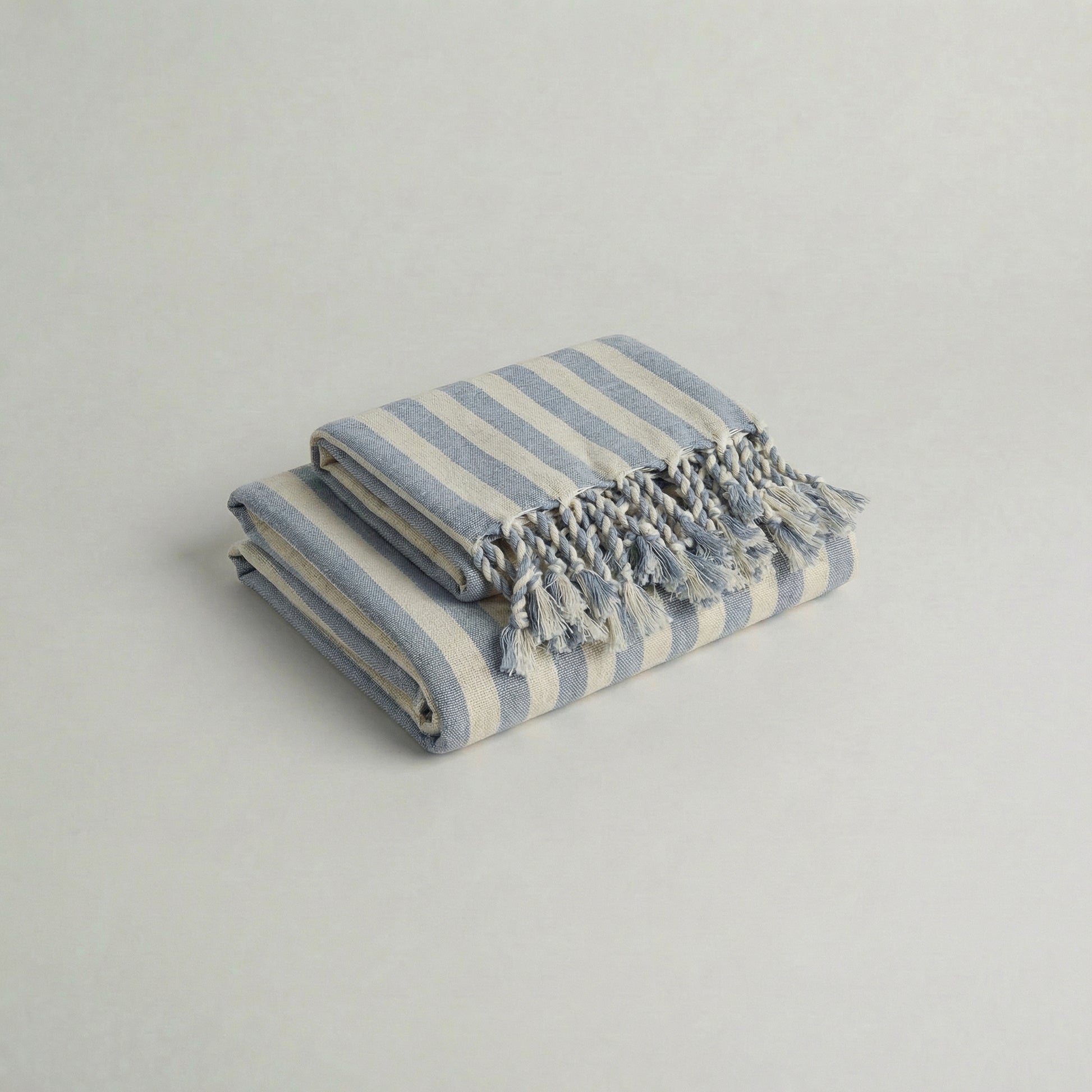 Folded handwoven cotton towel set with baby blue stripes and tassels