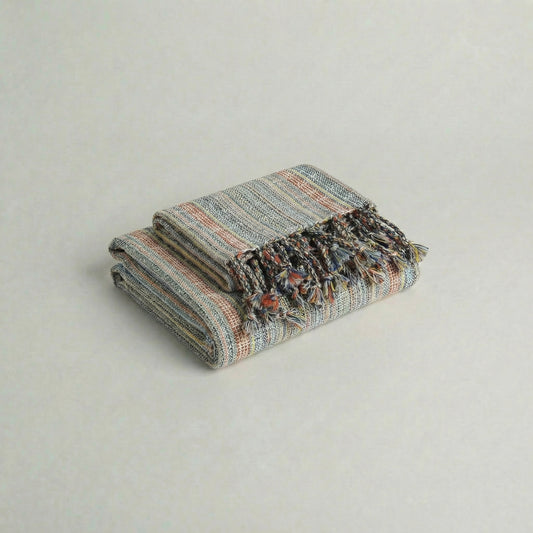 Folded handwoven slub turkish cotton towel with colorful patterns on a light gray background from atelier orea