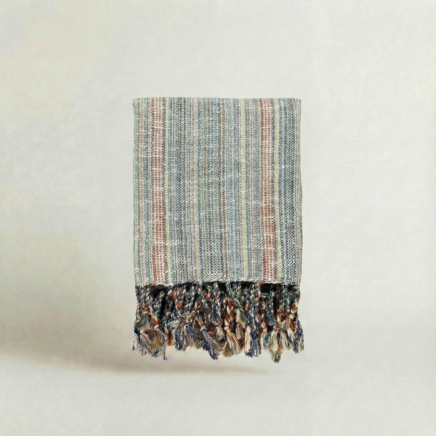 Textured handwoven slub turkish cotton atelier orea towel with frayed edges on a light background