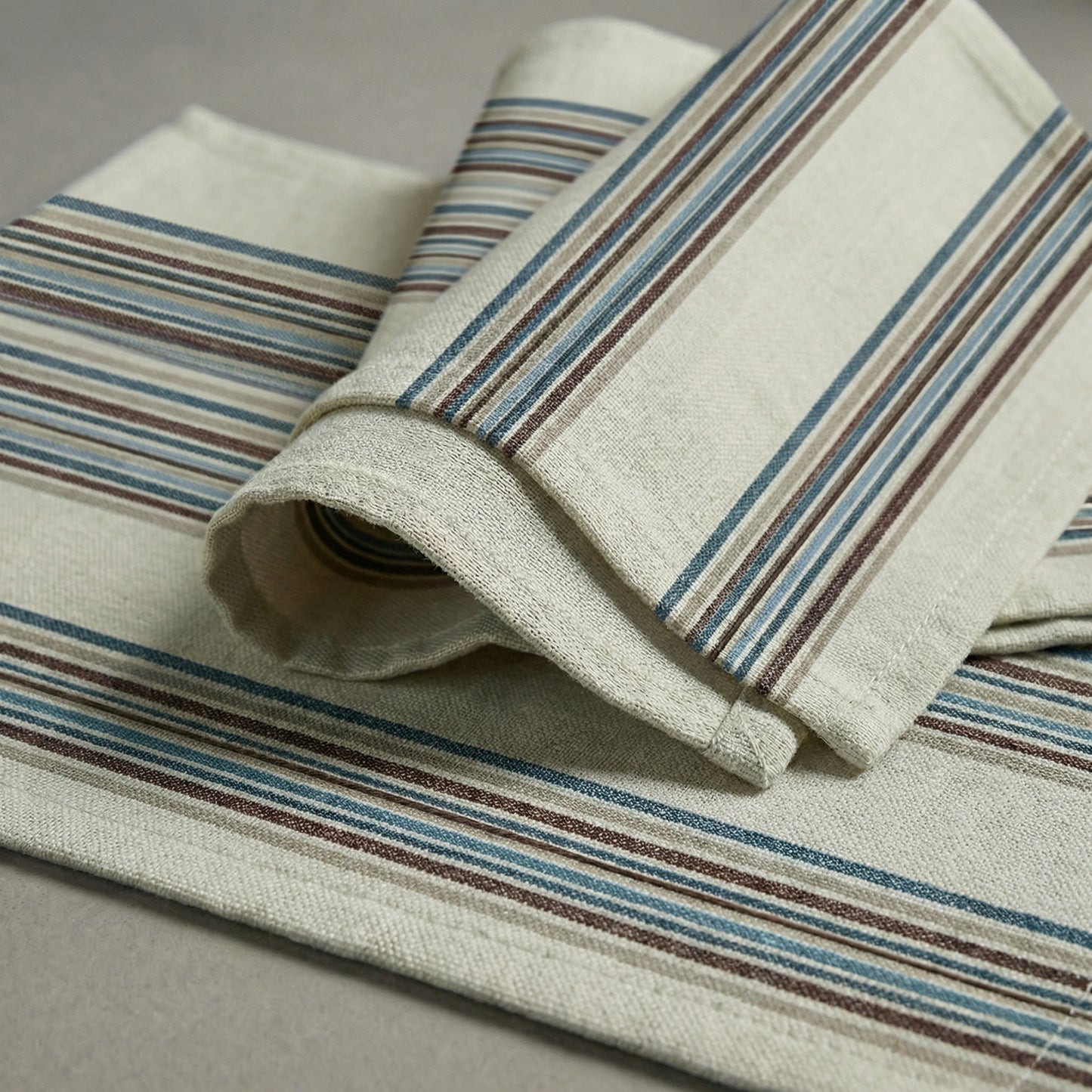 Rolled-up fabric with striped pattern on a neutral background handwoven cotton
