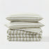 Stack of sage striped bedding with two pillows on a white background