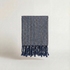 Handwoven turkish cotton towel navy brown striped with tassels on a light background