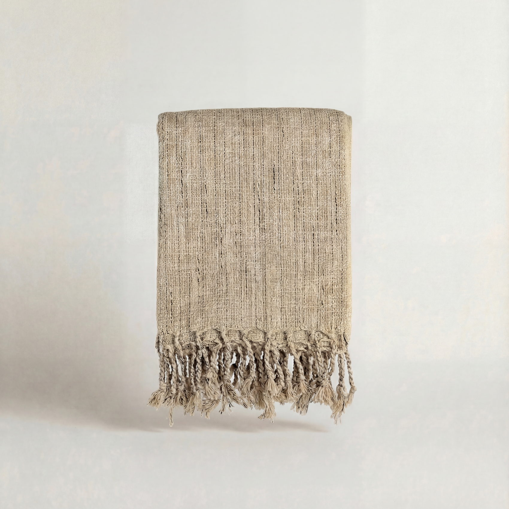Textured handwoven atelier orea towels with fringes on a plain background