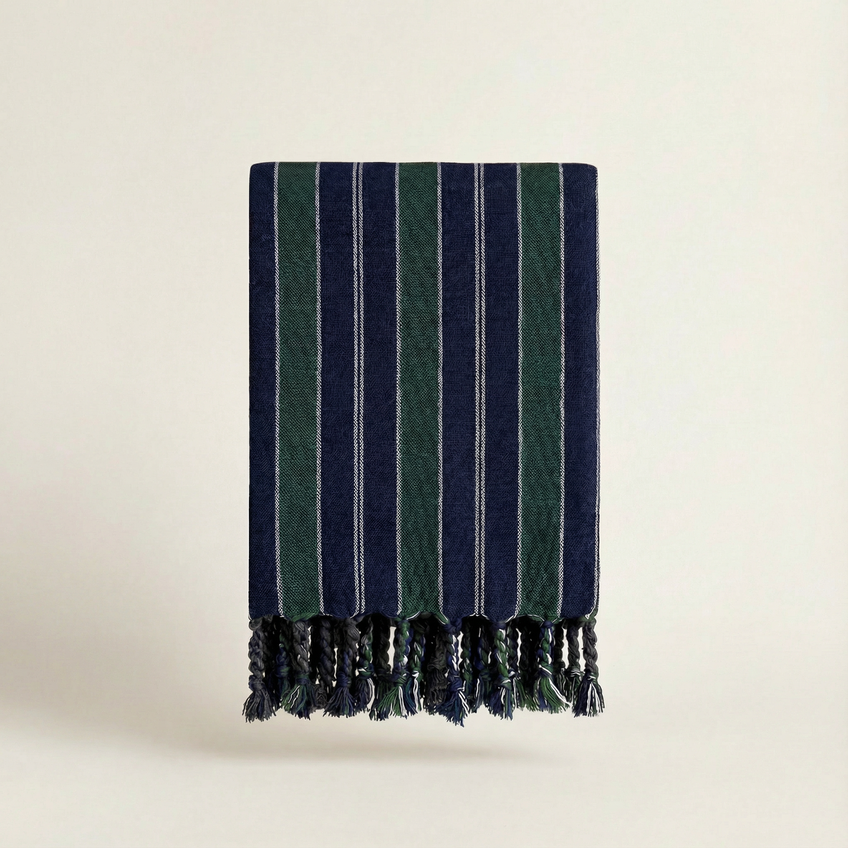 Striped towel with green and navy pattern on a beige background
