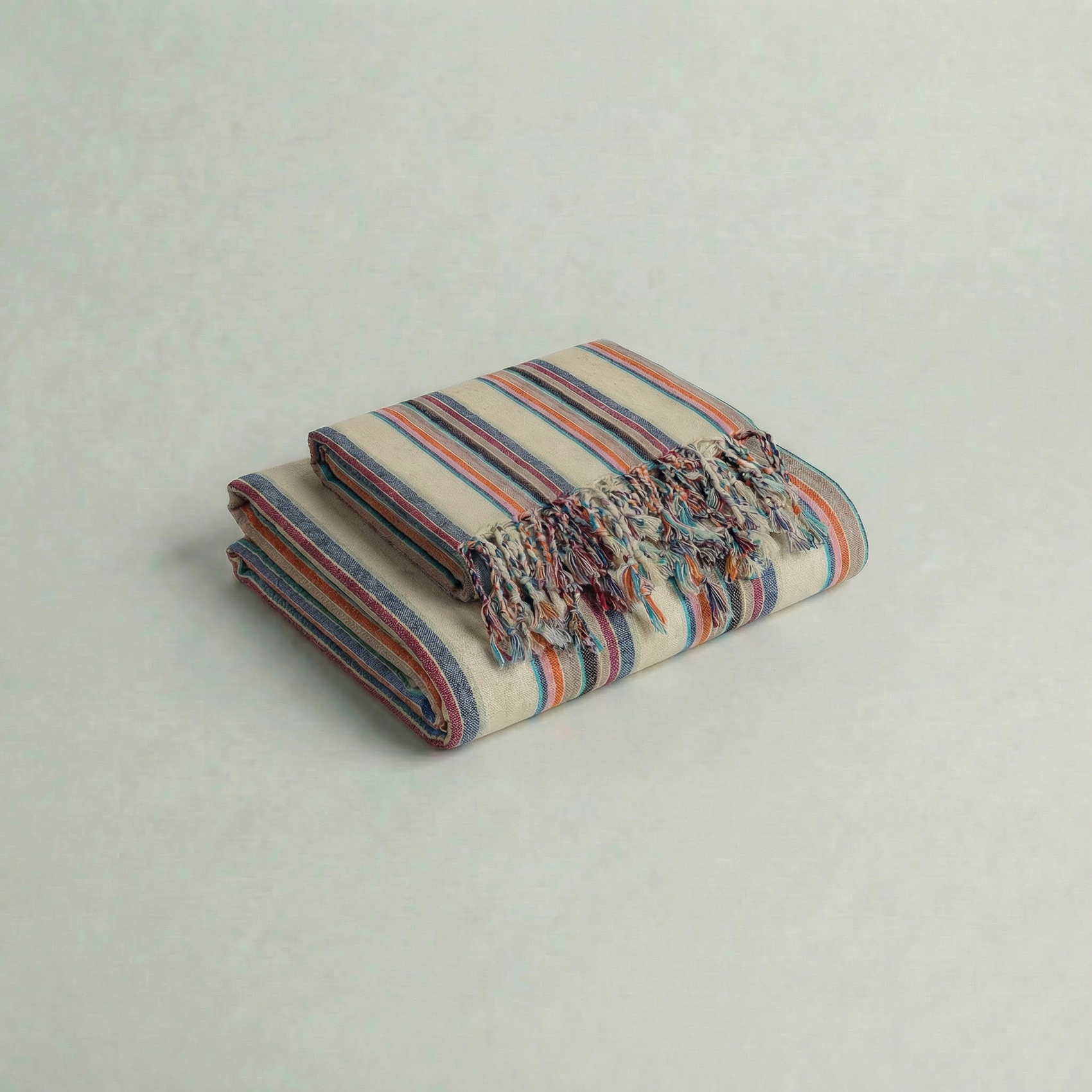 multi colored striped towel set with fringes on a light gray background