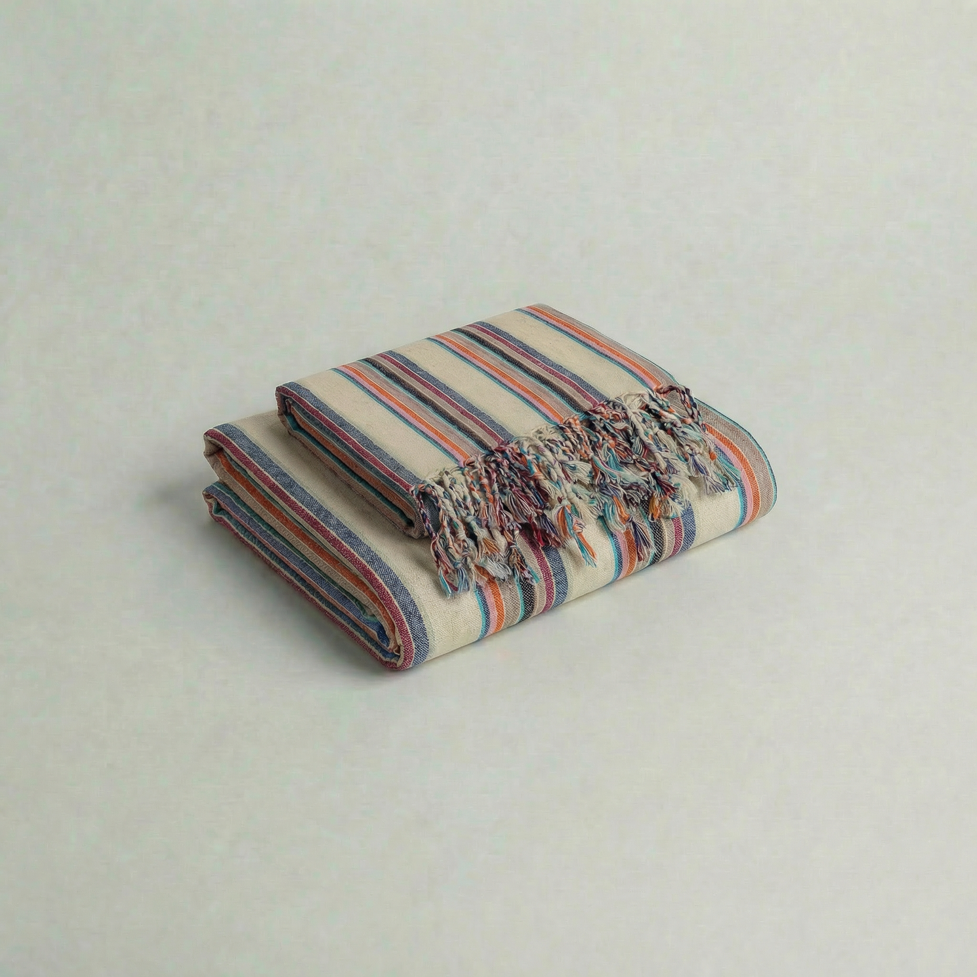 multi colored striped towel set with fringes on a light gray background