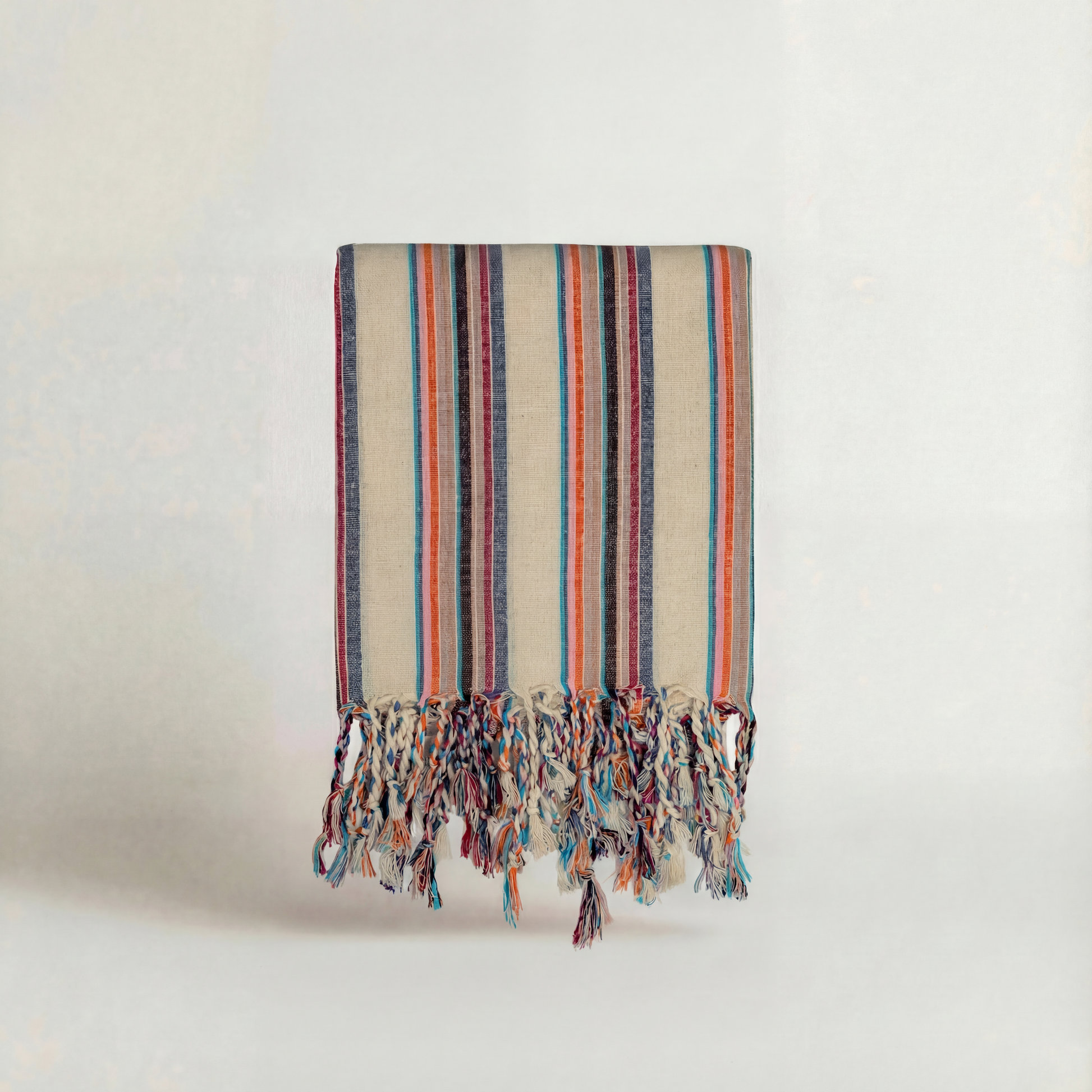 Striped handwoven atelier orea towels  with colorful fringes on a light background