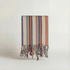 Striped handwoven atelier orea towels  with colorful fringes on a light background