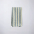 folded baby blue striped cotton napkin on a beige background