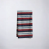 Striped napkin with maroon, blue, and white colors on a light gray background