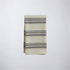 Folded cotton napkin with soft brown and blue striped pattern on a white background